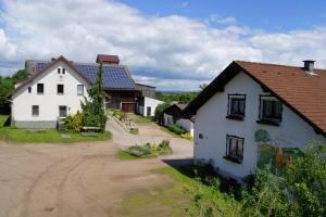 uma aldeia com dois edifícios brancos e uma estrada de terra em Bio-Erlebnisbauernhof Doll em Nittenau