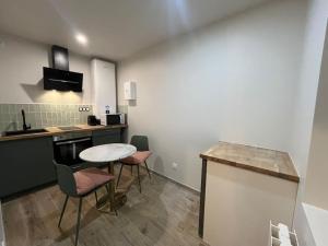 cocina con mesa, sillas y barra en ESCAPADE Sereine - Studio Balnéo à Laval, en Laval