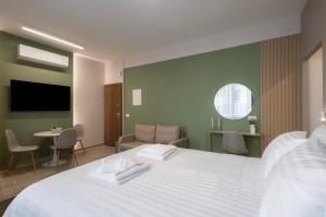 a bedroom with a large white bed and a table at CityLuxe Center Ioannina in Ioannina