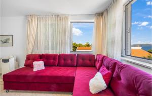 a red couch in a room with a large window at 4 Bedroom Amazing Home In Zaboric in Zaboric