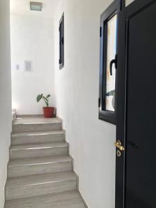 a staircase with a black door and a potted plant at Sierra Alta Carlos Paz in Villa Carlos Paz