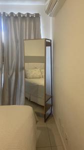 a mirror in the corner of a bedroom with a bed at Mediterrâneo 507 - Todo Equipado, Ar Condicionado, Churrasqueira na Varanda, Internet Fibra 600MB, Estacionamento Grátis in Cabo Frio