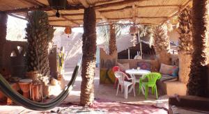 un patio con mesa y sillas en una casa en Auberge Tigida, en Mhamid