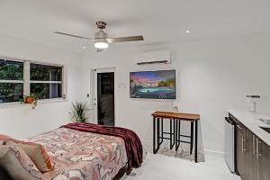 Un dormitorio con una cama y un televisor en la pared. en Entire Luxury Junior Suite, 8 min from the Beach, Suite 2, en Fort Lauderdale