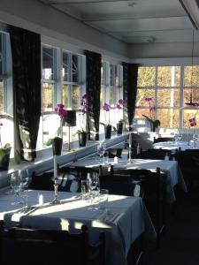 een rij tafels in een kamer met ramen bij Blommenslyst Kro in Blommenslyst