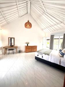 a bedroom with a bed and a desk in it at Greenhouse Villa in Kerobokan +23 photos