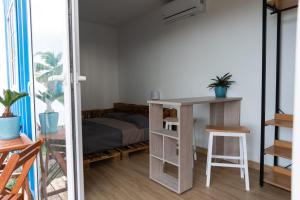 a room with a bed and a table and a desk at Panama Kite House - Kite, Eat, Sleep, Repeat in Punta Chame