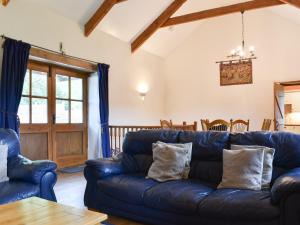 a living room with a blue couch and a table at Woods Close -17381 in Kilkhampton