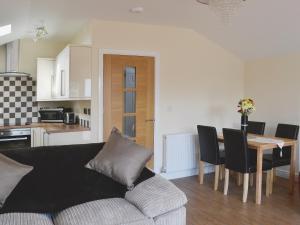 a living room with a couch and a dining room table at Oak Cottage in Winthorpe