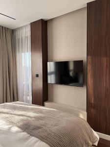 a bedroom with a bed with a tv on the wall at ZEST privè in Kragujevac +26 photos