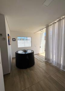 ein Wohnzimmer mit einem Tisch in der Mitte eines Zimmers in der Unterkunft Linda Casa em Praia de Gravatá in São José da Coroa Grande