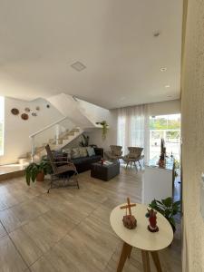 ein Wohnzimmer mit Sofa und Tisch in der Unterkunft Linda Casa em Praia de Gravatá in São José da Coroa Grande