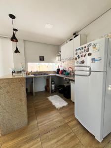 eine Küche mit einem weißen Kühlschrank und Holzböden in der Unterkunft Linda Casa em Praia de Gravatá in São José da Coroa Grande