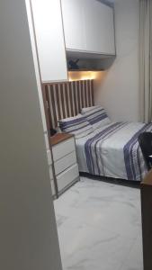 a bedroom with a bed and a tv on the wall at Itapuã Beach II Espaço climatizado com piscina privativa e área gourmet! in Salvador
