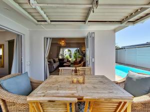 a dining room with a wooden table and chairs at Strand Boat House in Cape Town