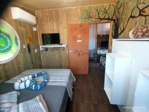 a bedroom with a bed and a wall with a tree mural at Tapera Florianópolis in Florianópolis