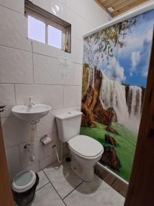 a bathroom with a toilet and a waterfall shower curtain at Tapera Florianópolis in Florianópolis +21 photos