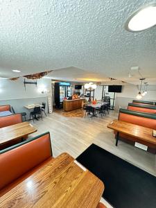 a dining room with tables and chairs and a living room at Days Inn by Wyndham Mandan Bismarck Area in Mandan