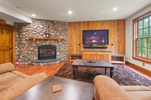 a living room with a stone fireplace and a tv at Rustic & Comfy Retreat Elevator - Hot Tub - Games in Lincoln
