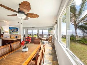 a dining room with a table and a ceiling fan at Ocean Front Paradise with Hot Tub in Hawaii in Keaau