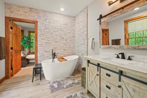 a bathroom with a large tub and a sink at Rustic & Comfy Retreat Elevator - Hot Tub - Games in Lincoln +50 photos