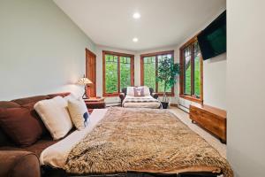 a living room with a large bed and a couch at Rustic & Comfy Retreat Elevator - Hot Tub - Games in Lincoln