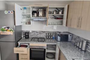 a kitchen with a refrigerator and a stove top oven at Grayappart Kénitra in Kenitra
