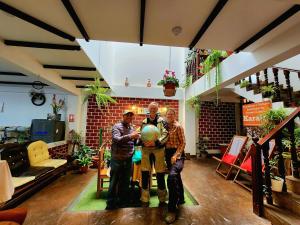 three men standing in a living room holding a globe at Chachapoyas Backpackers Hostal Boutique in Chachapoyas