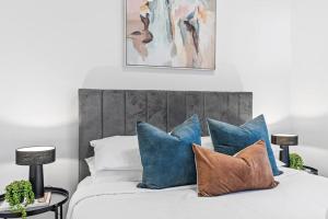 a bedroom with a bed with blue and brown pillows at Barkly Beachside Escape in Melbourne