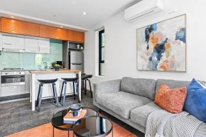 a living room with a couch and a kitchen at Barkly Beachside Escape in Melbourne
