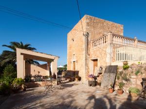 un edificio con un patio con mesas y sillas en S´Hort de Can Carrió, en Ses Salines