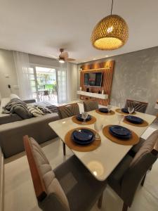 a living room with a table and a couch at Condomínio Clube lazer total na Praia da Enseada in Guarujá +24 photos