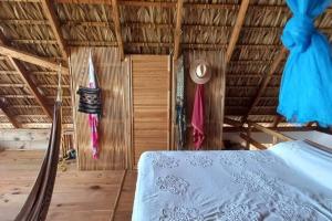 a bedroom with a bed and a thatch roof at casa cabaña con vista al océano in Zipolite