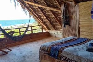 a bedroom with a hammock and a view of the ocean at casa cabaña con vista al océano in Zipolite