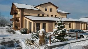 a house with a christmas tree in the snow at Sportpenzion Pohoda in Pilsen