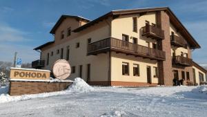 a large building with a sign in the snow at Sportpenzion Pohoda in Pilsen