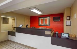una sala de espera con un contador de teléfono y una pared roja en Extended Stay America Suites - Charleston - Airport, en Charleston