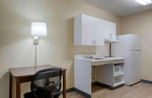a small kitchen with a desk and a white refrigerator at Extended Stay America Suites - Fairbanks - Old Airport Way in Fairbanks