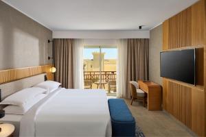 a hotel room with a bed and a flat screen tv at Sheraton Soma Bay Resort in Hurghada