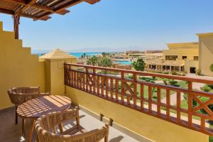 a balcony with tables and chairs and a view of the ocean at Sheraton Soma Bay Resort in Hurghada