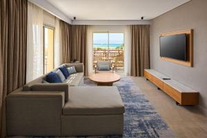 a living room with a couch and a flat screen tv at Sheraton Soma Bay Resort in Hurghada