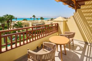 a balcony with a table and chairs and the beach at Sheraton Soma Bay Resort in Hurghada