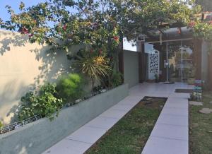 a house with a porch with flowers on it at Casa de praia natureza in Torres
