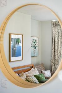 a mirror reflecting a couch in a living room at Luxe Comfort En-Suite Room 1 in Oxford