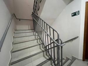 a staircase with a metal railing in a building at Apt no Santa Mônica próximo ao Pátio Sabiá, UFU in Uberlândia