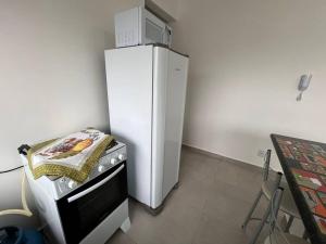 a white refrigerator in a kitchen with a stove at Apt no Santa Mônica próximo ao Pátio Sabiá, UFU in Uberlândia