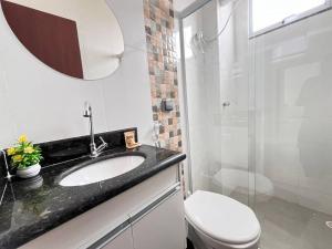 a bathroom with a toilet and a sink and a shower at Apt no Santa Mônica próximo ao Pátio Sabiá, UFU in Uberlândia