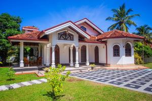 a house with a palm tree in the background at Chilaw D&D Holiday Home in Welihena