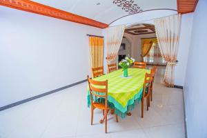 a dining room with a green table and chairs at Chilaw D&D Holiday Home in Welihena