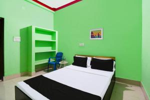 JagatpurにあるHotel O Peaceful Innの緑のベッドルーム(ベッド1台、青い椅子付)